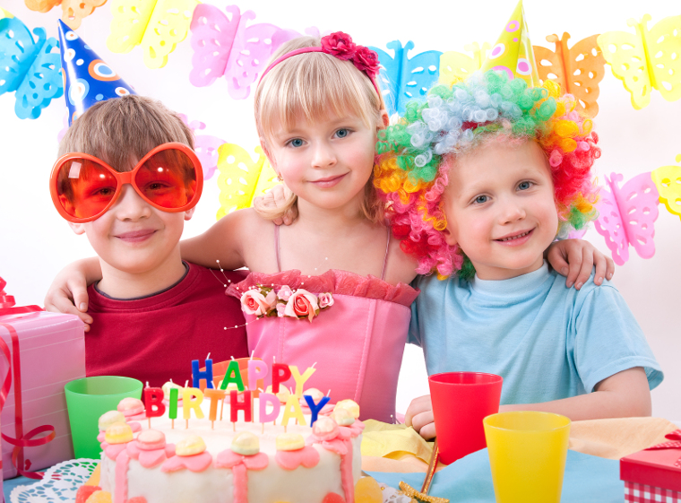 Three kids are happily posing during birthday party