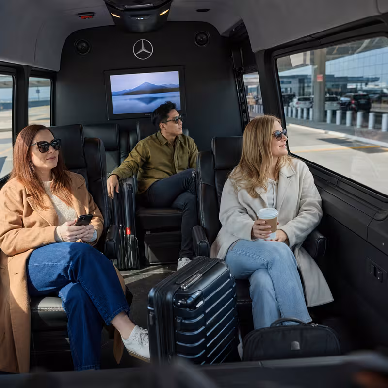 Passengers loading luggage while boarding an Plano group shuttle