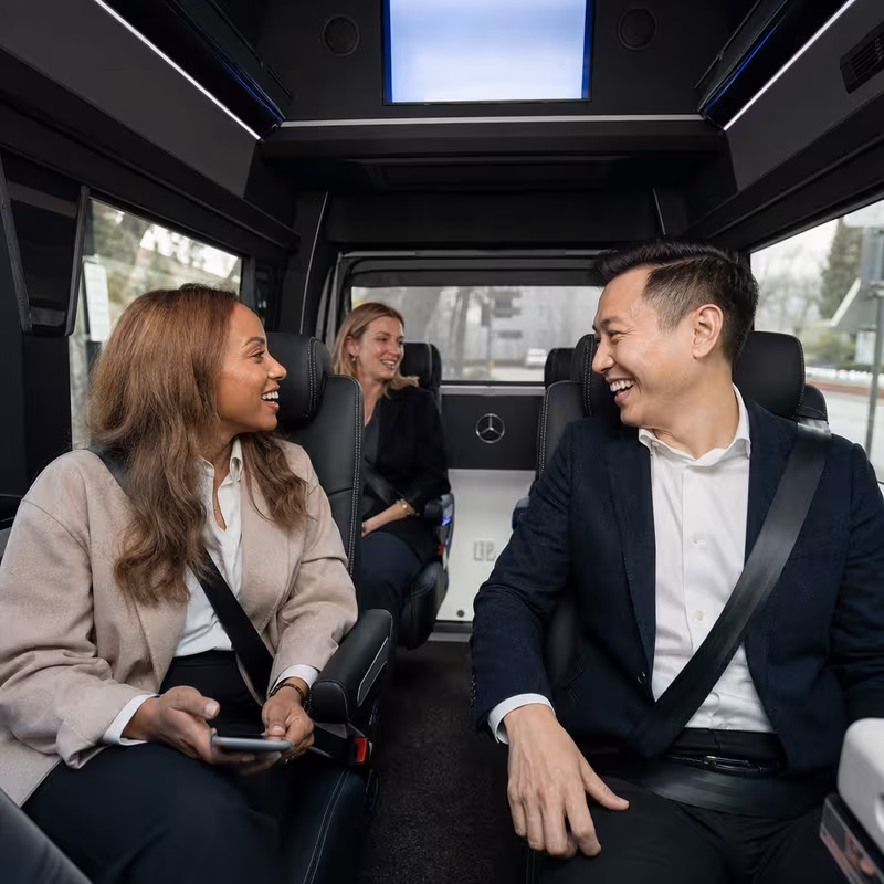 Group boarding a white charter bus for Corporate Transportation transportation in Plano