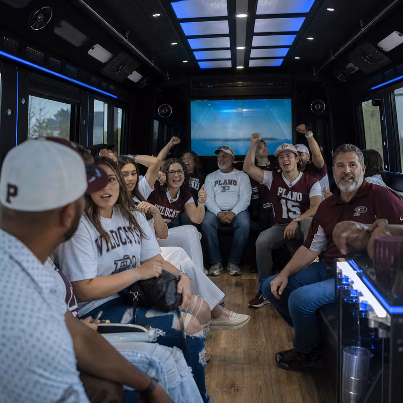 Group boarding a white charter bus for Sporting Event Transportation transportation in Plano