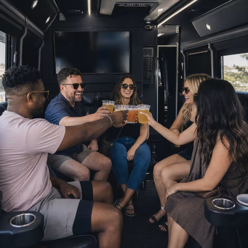 Group boarding a white charter bus for Winery & Brewery Tour Transportation transportation in Plano